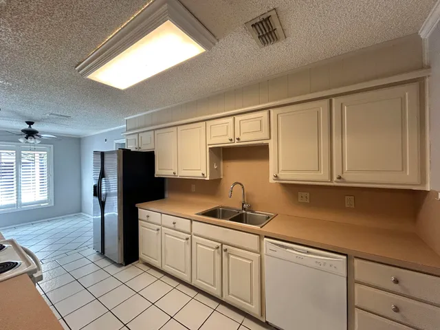 a kitchen with stainless steel appliances white cabinets and a refrigerator