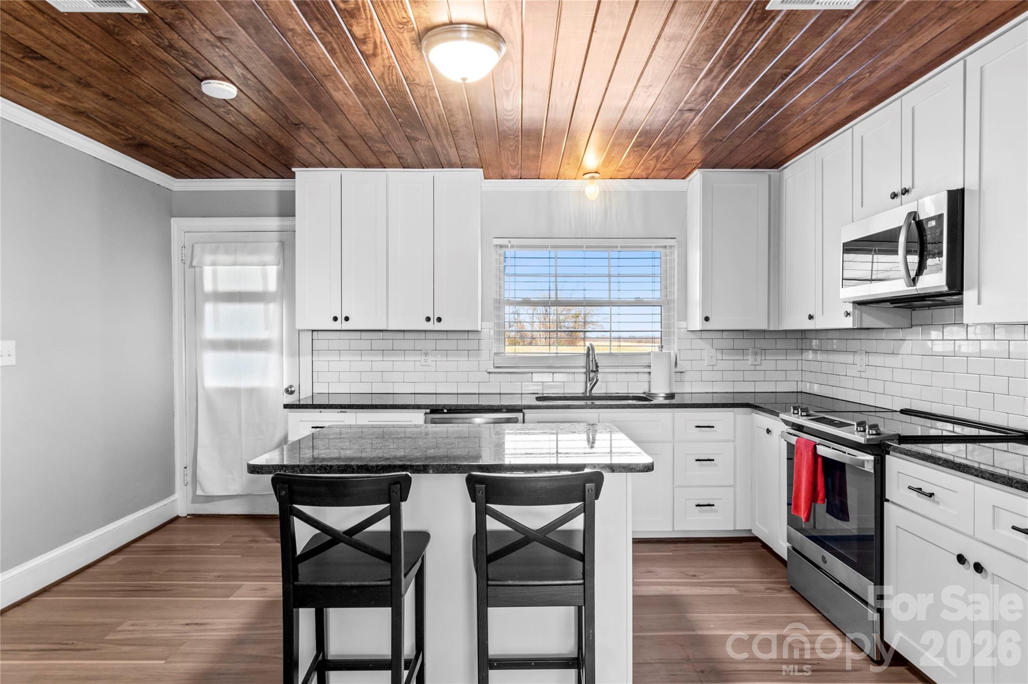 2432 Holcomb Road Yadkinville, NC 27055 - Photo 13 of 37 a kitchen with stainless steel appliances granite countertop wooden cabinets a stove a sink and dishwasher