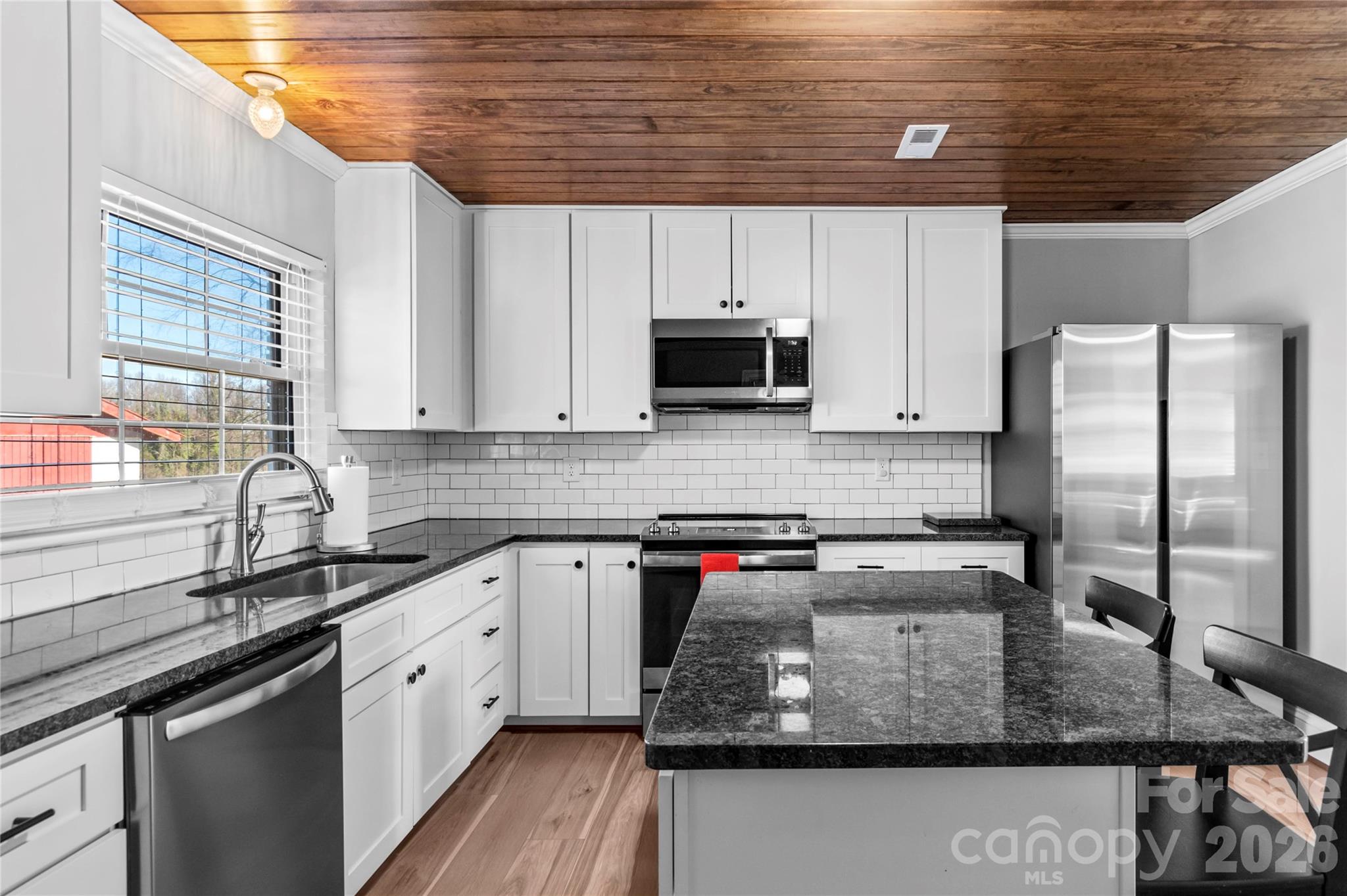 2432 Holcomb Road Yadkinville, NC 27055 - Photo 15 of 37 a kitchen with stainless steel appliances granite countertop a sink a stove and cabinets