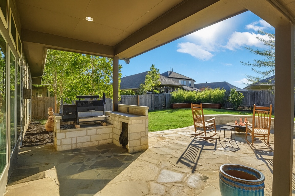 541 Cortona Lane Georgetown, TX 78628 - Photo 15 of 19 a view of a patio with a dining table and chairs with a small yard