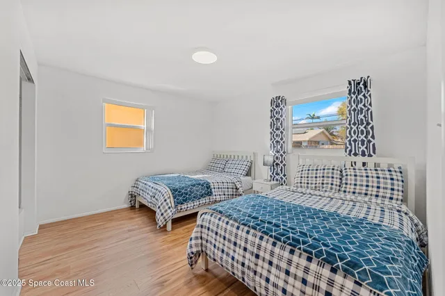 a bedroom with two beds and a window