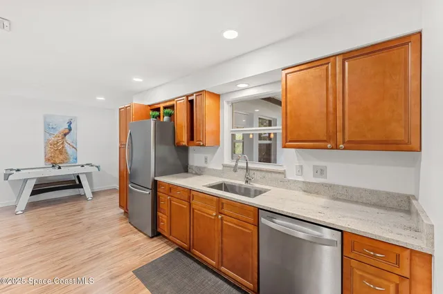 a kitchen with stainless steel appliances granite countertop a refrigerator and a sink