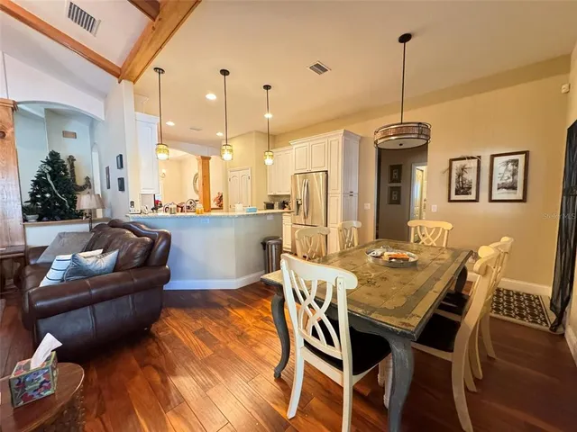 a view of a dining room and livingroom with furniture wooden floor a chandelier