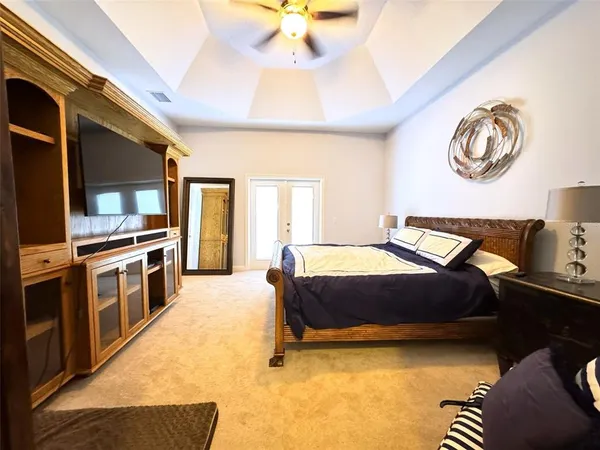 a spacious bedroom with a bed and a chandelier