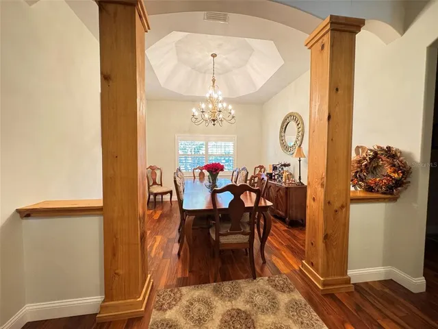 a view of a dining room with furniture and a chandelier