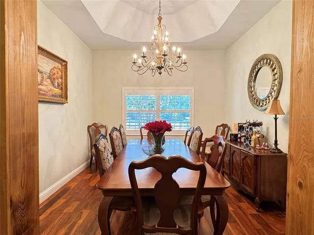 a view of a dining room with furniture a chandelier and wooden floor