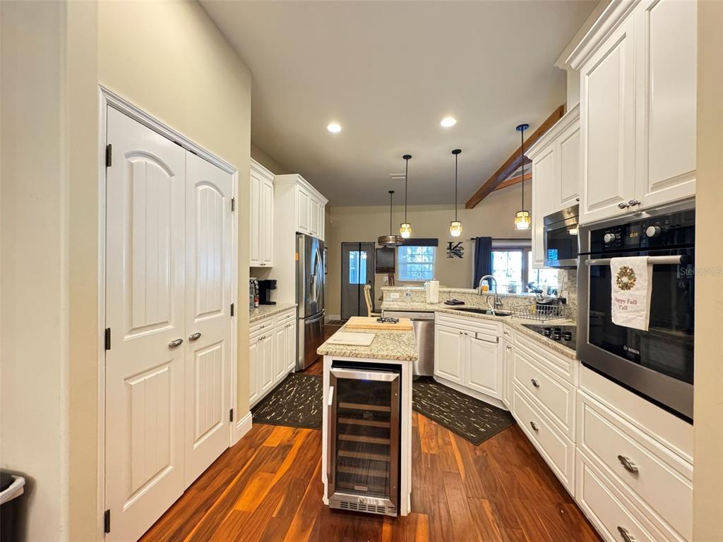 3108 North Wheaton Point Hernando, FL 34442 - Photo 8 of 35 a large white kitchen with a stove a sink and dishwasher with wooden floor