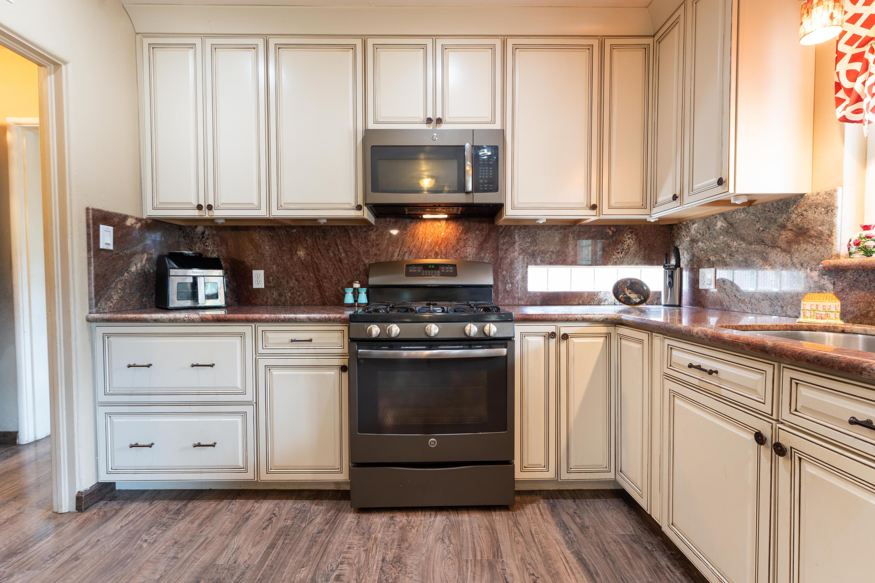 570 North Birch Avenue Reedley, CA 93654 - Photo 16 of 52 a kitchen with stainless steel appliances granite countertop a stove and a microwave