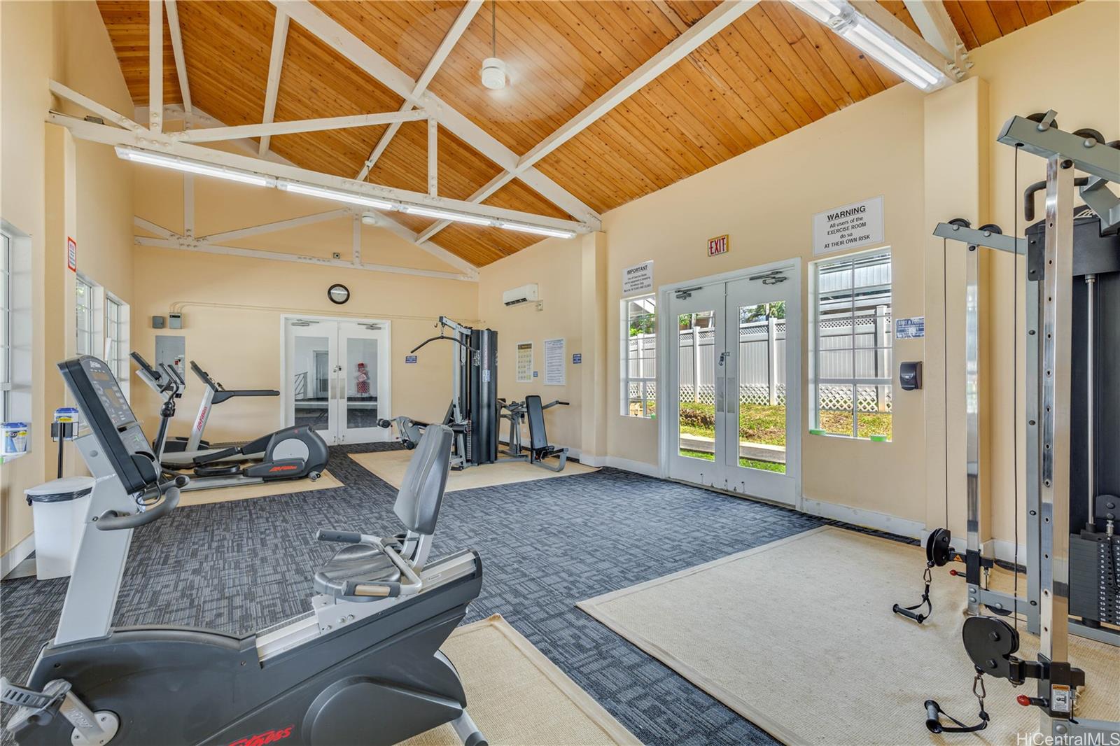 432 Mananai Place, Unit 18C Honolulu, HI 96818 - Photo 16 of 17 a living room with furniture gym equipment and a rug