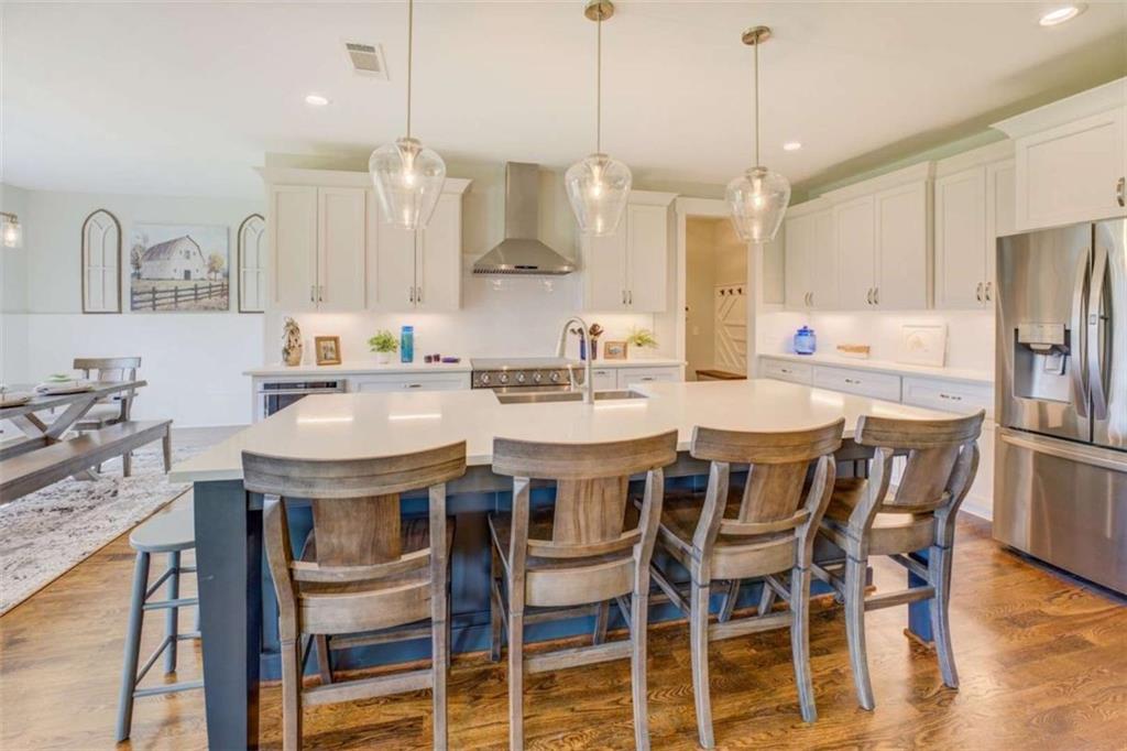 3076 East Lake Road McDonough, GA 30252 - Photo 13 of 49 a kitchen with a dining table chairs sink and cabinets