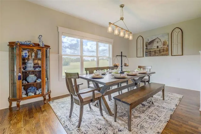 a view of a a dining room with furniture window and wooden floor