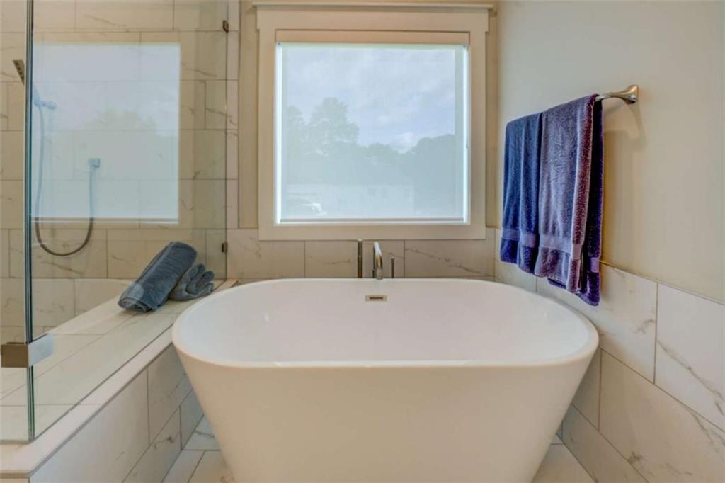 3076 East Lake Road McDonough, GA 30252 - Photo 28 of 49 a white bath tub sitting in a bathroom next to a window