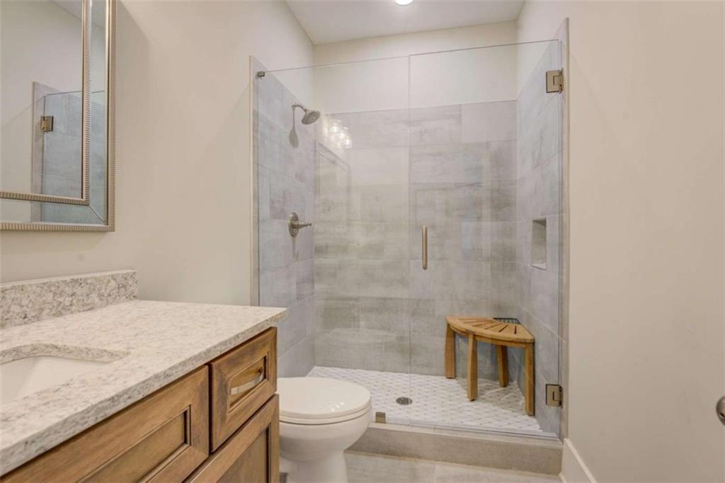 3076 East Lake Road McDonough, GA 30252 - Photo 32 of 49 a bathroom with a granite countertop sink a toilet and shower