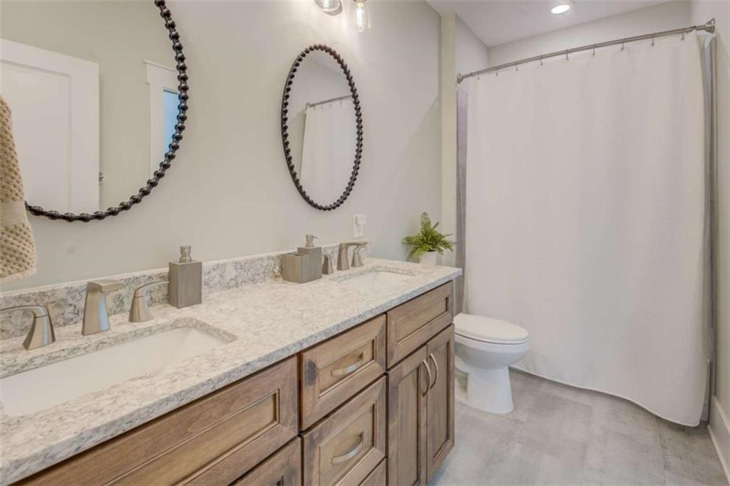 3076 East Lake Road McDonough, GA 30252 - Photo 37 of 49 a bathroom with a granite countertop sink mirror and toilet