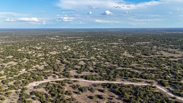 an aerial view of house with yard and mountain view in back