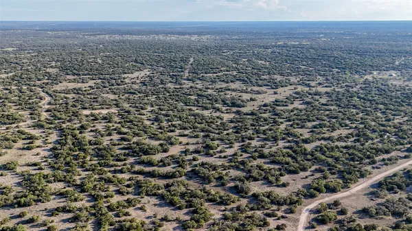 an aerial view of house with yard and mountain in a back yard