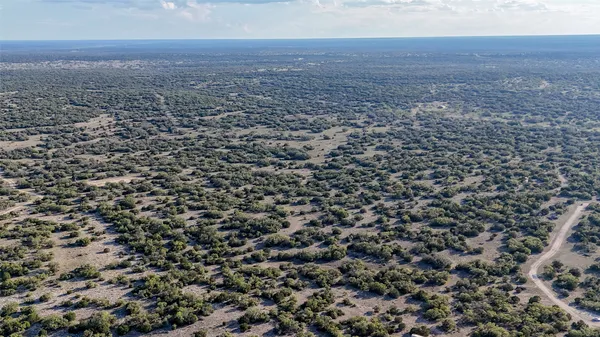 an aerial view of house with yard and mountain view in back