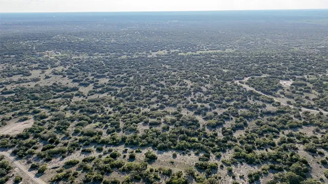 an aerial view of house with yard and mountain view in back