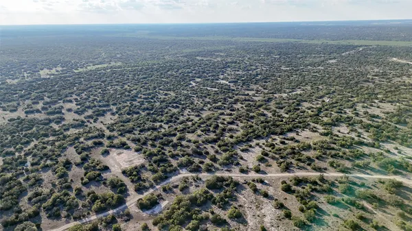 an aerial view of house with yard and mountain view in back