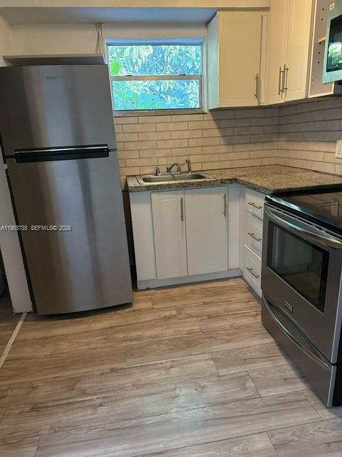 90 Northeast 68th Street, Unit 90 Miami, FL 33138 - Photo 2 of 5 a kitchen with granite countertop a refrigerator sink and cabinets