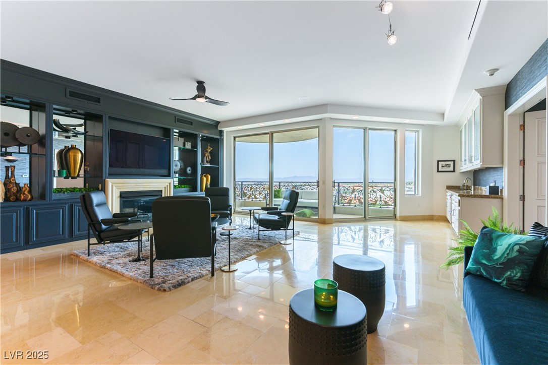 9101 Alta Drive, Unit 505 Las Vegas, NV 89145 - Photo 11 of 64 Living room featuring a glass covered fireplace and a ceiling fan