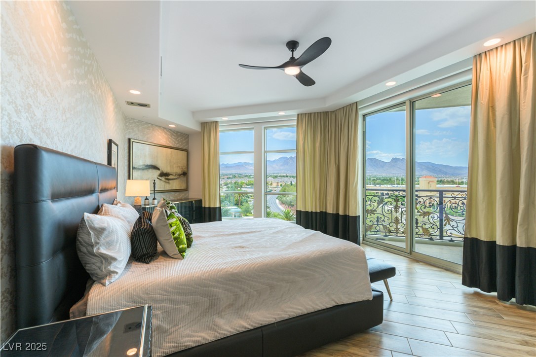 9101 Alta Drive, Unit 505 Las Vegas, NV 89145 - Photo 22 of 64 Bedroom with multiple windows, access to outside, wood finished floors, a mountain view, and recessed lighting