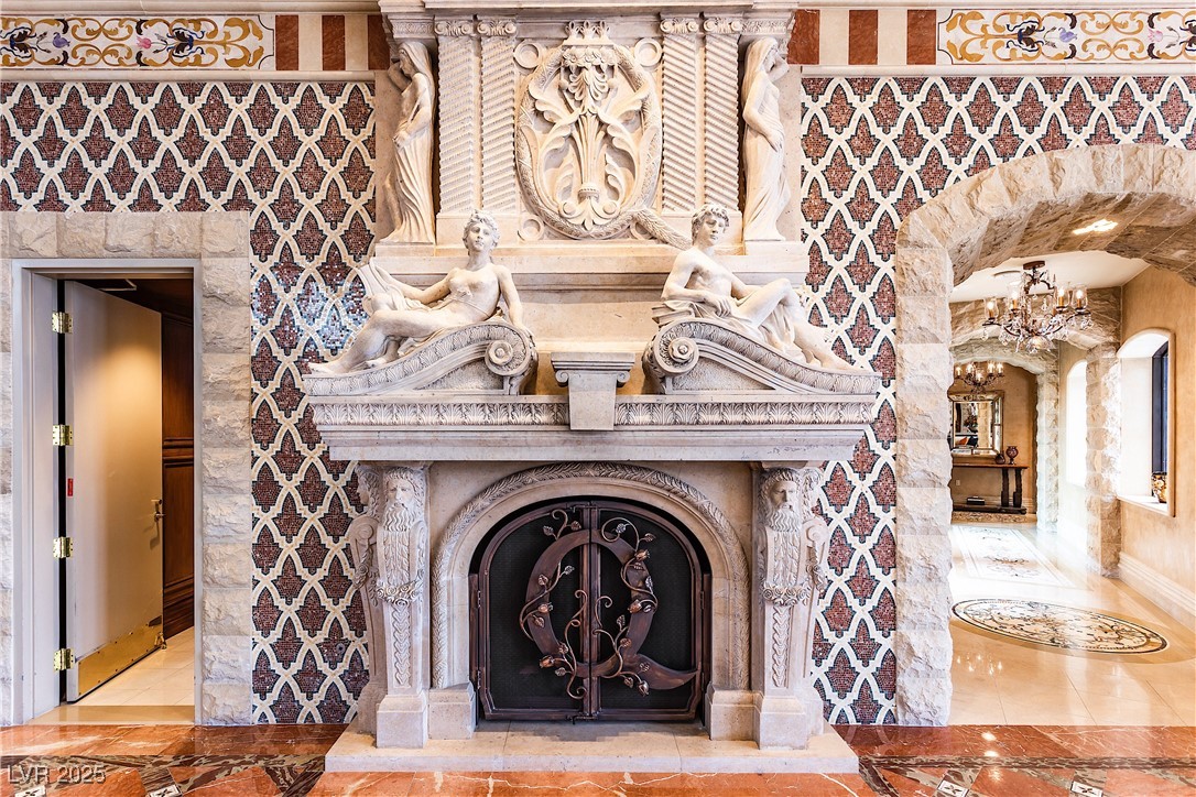 9101 Alta Drive, Unit 505 Las Vegas, NV 89145 - Photo 48 of 64 Detailed view of inlaid floor details, wallpapered walls, arched walkways, a chandelier, and a fireplace
