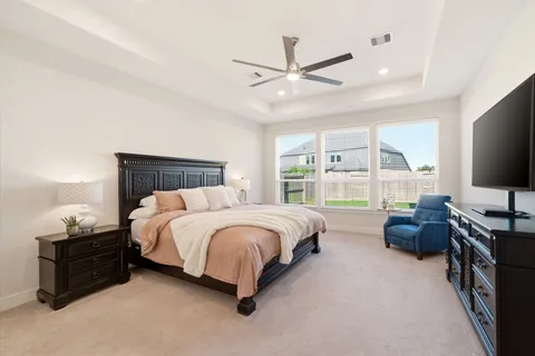 a spacious bedroom with a bed and a flat screen tv