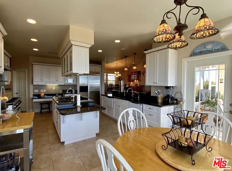 7173 Barker Road Oak Hills, CA 92344 - Photo 11 of 26 a kitchen with stainless steel appliances kitchen island granite countertop a dining table and chairs