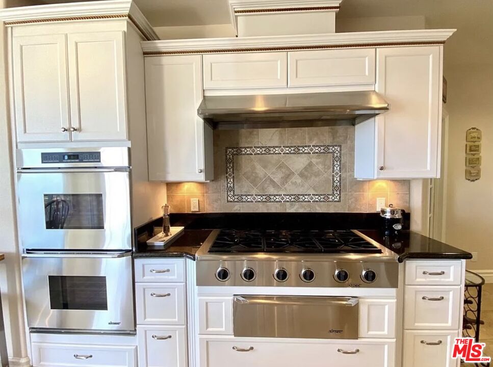 7173 Barker Road Oak Hills, CA 92344 - Photo 12 of 26 a stove top oven sitting inside of a kitchen