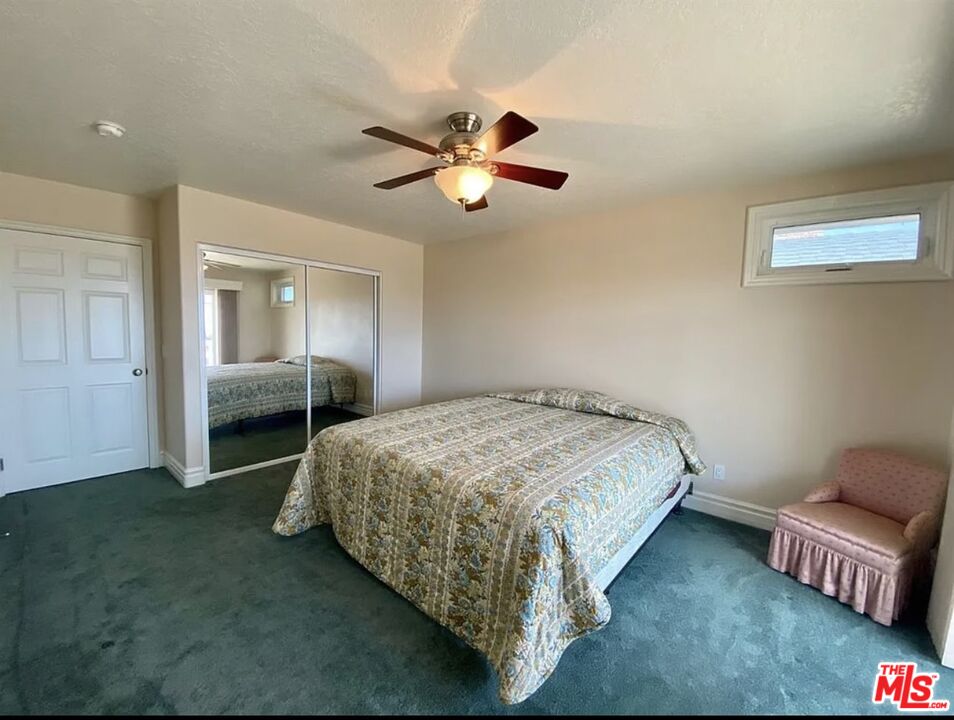 7173 Barker Road Oak Hills, CA 92344 - Photo 17 of 26 a bedroom with a bed and a chandelier