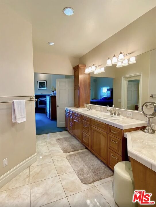 7173 Barker Road Oak Hills, CA 92344 - Photo 20 of 26 a spacious bathroom with a granite countertop sink and a mirror