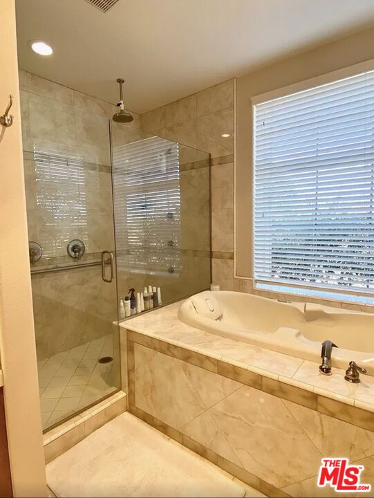7173 Barker Road Oak Hills, CA 92344 - Photo 22 of 26 a bathroom with a bathtub and a shower