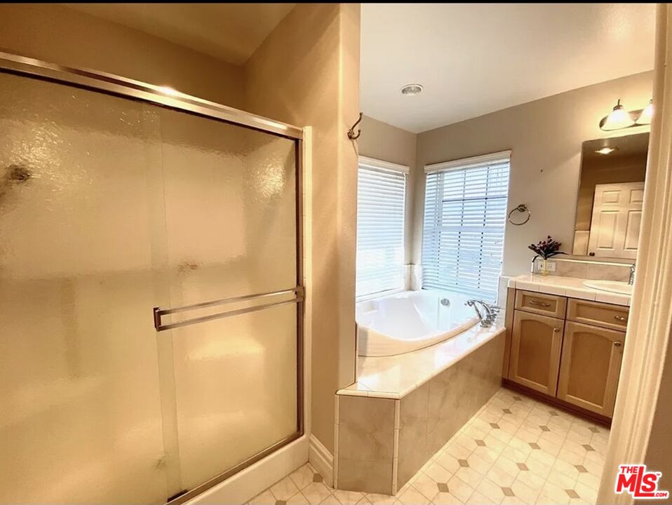 7173 Barker Road Oak Hills, CA 92344 - Photo 25 of 26 a bathroom with a tub a sink and a shower