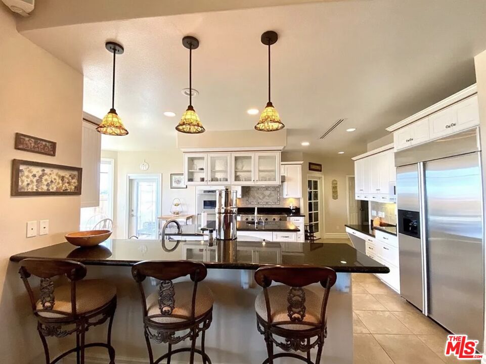 7173 Barker Road Oak Hills, CA 92344 - Photo 9 of 26 a kitchen with stainless steel appliances kitchen island granite countertop a sink and cabinets