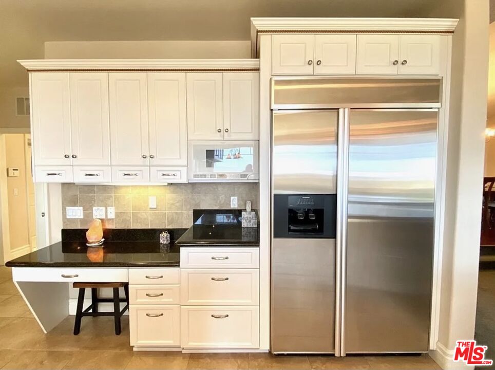 7173 Barker Road Oak Hills, CA 92344 - Photo 10 of 26 a kitchen with cabinets and a refrigerator