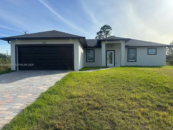 a view of a house with a yard and a garage