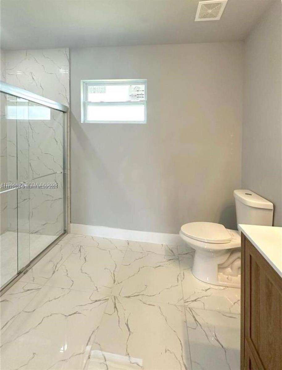 868 Cervantes Street East Lehigh Acres, FL 33974 - Photo 14 of 18 a white toilet sitting next to a bathroom