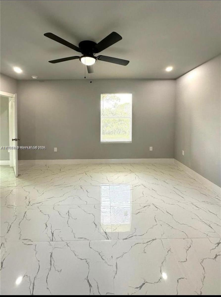 868 Cervantes Street East Lehigh Acres, FL 33974 - Photo 15 of 18 an empty room with a ceiling fan and window