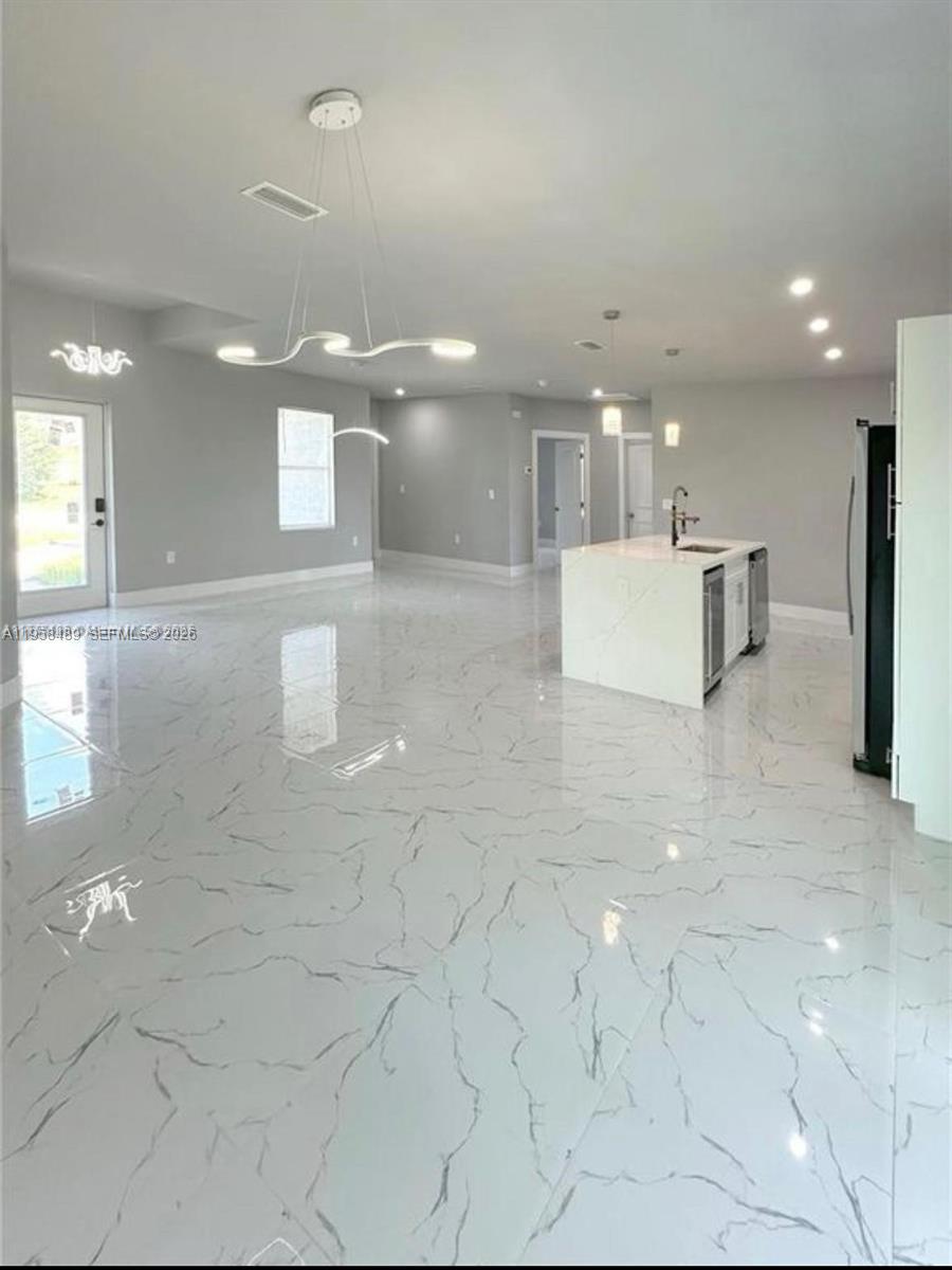 868 Cervantes Street East Lehigh Acres, FL 33974 - Photo 16 of 18 a view of a kitchen with a sink and chandelier