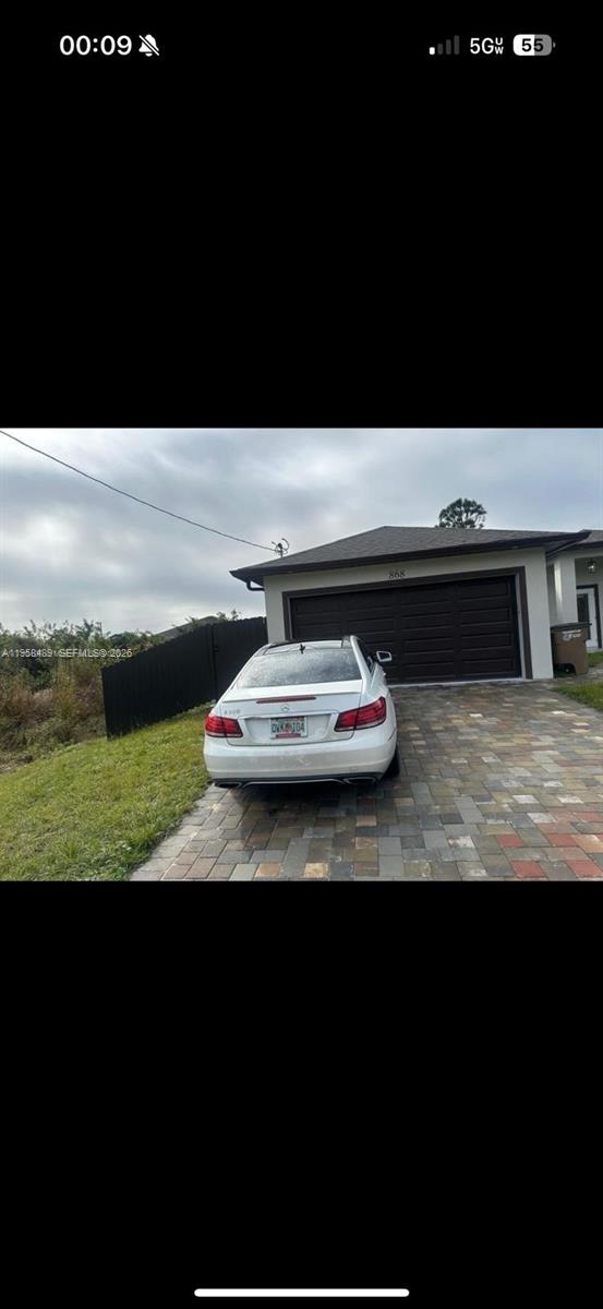 868 Cervantes Street East Lehigh Acres, FL 33974 - Photo 17 of 18 a view of a car parked in the yard