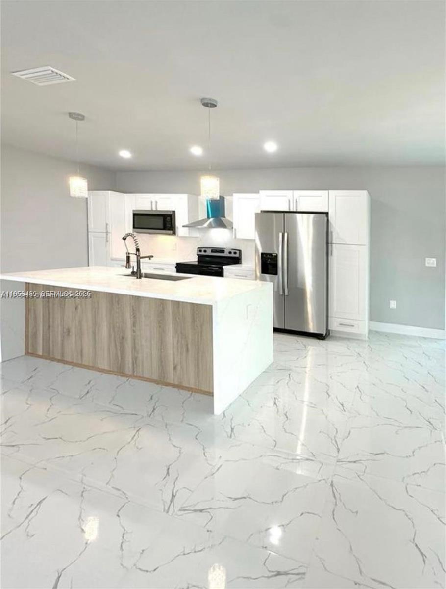 868 Cervantes Street East Lehigh Acres, FL 33974 - Photo 8 of 18 a large white kitchen with cabinets