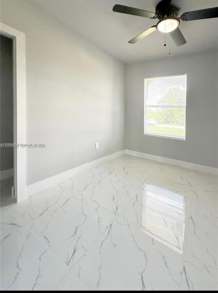868 Cervantes Street East Lehigh Acres, FL 33974 - Photo 9 of 18 an empty room with windows and fan