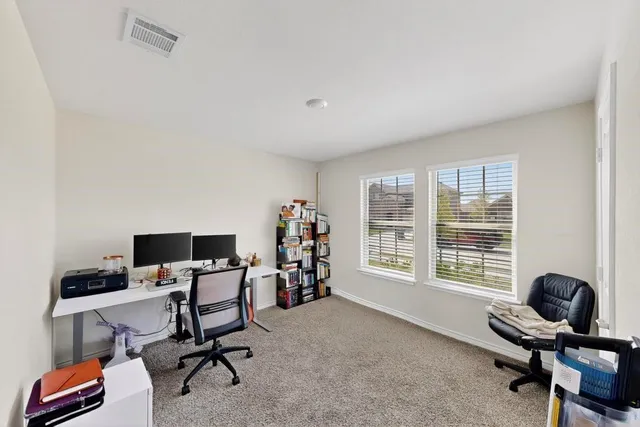 a view of a workspace with furniture and a window