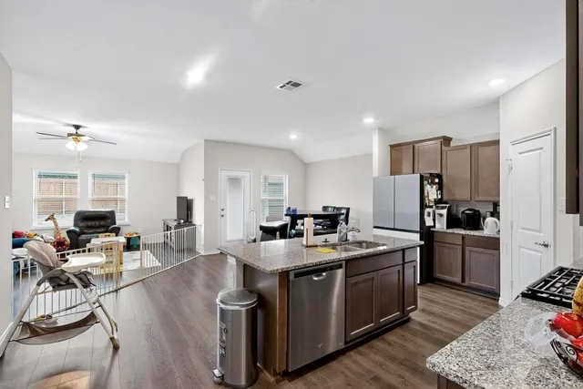 a kitchen with stainless steel appliances granite countertop a sink stove and refrigerator