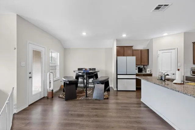 a large white kitchen with a refrigerator a sink dishwasher a stove and a refrigerator with wooden floor