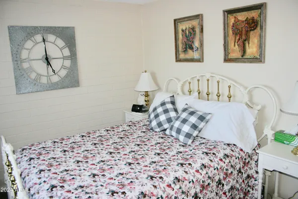 a bedroom with a bed and a painting on the wall