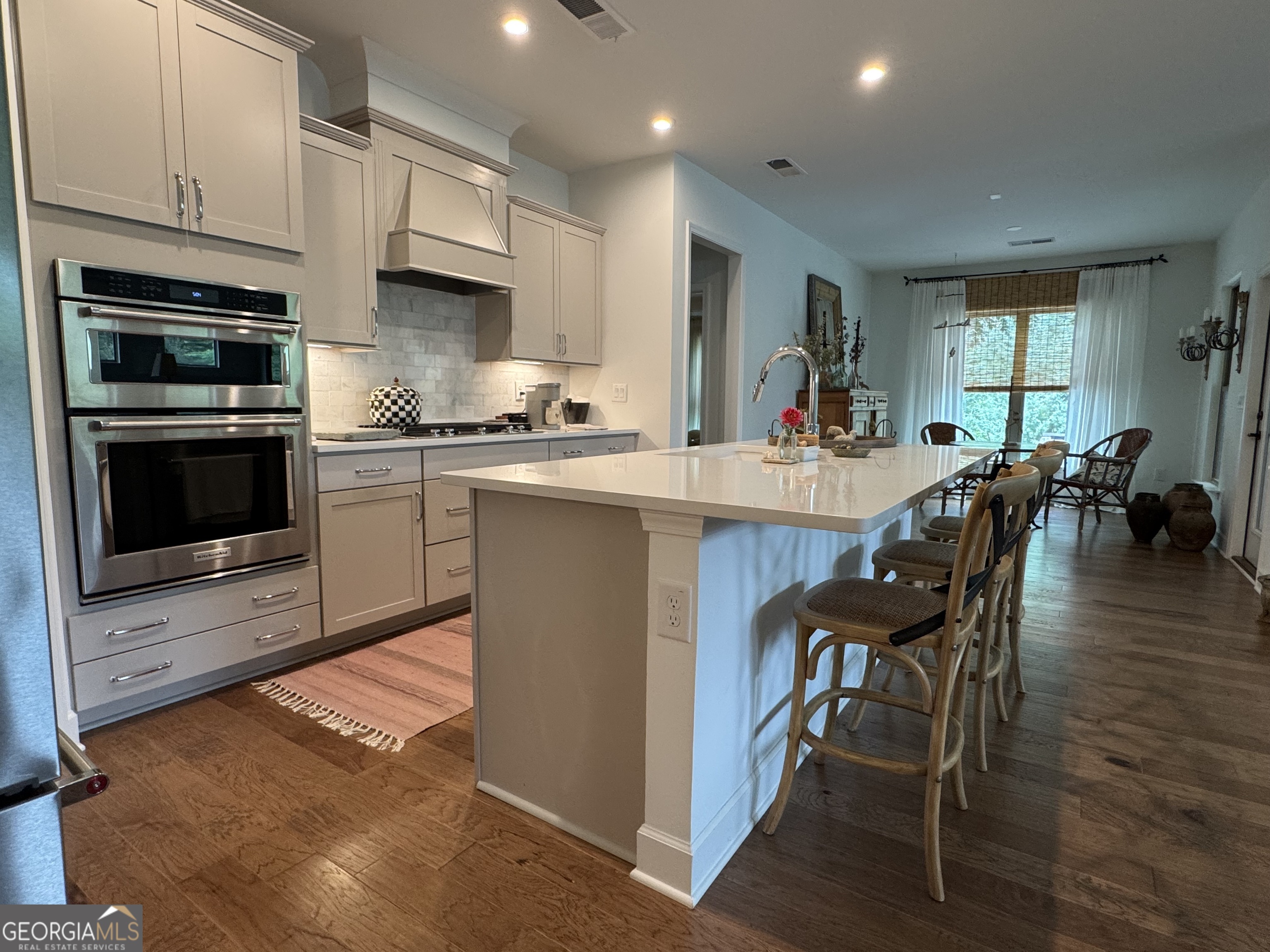 5947 Maple Bluff Way Hoschton, GA 30548 - Photo 13 of 32 a kitchen with stainless steel appliances a stove a sink a oven a dining table and chairs