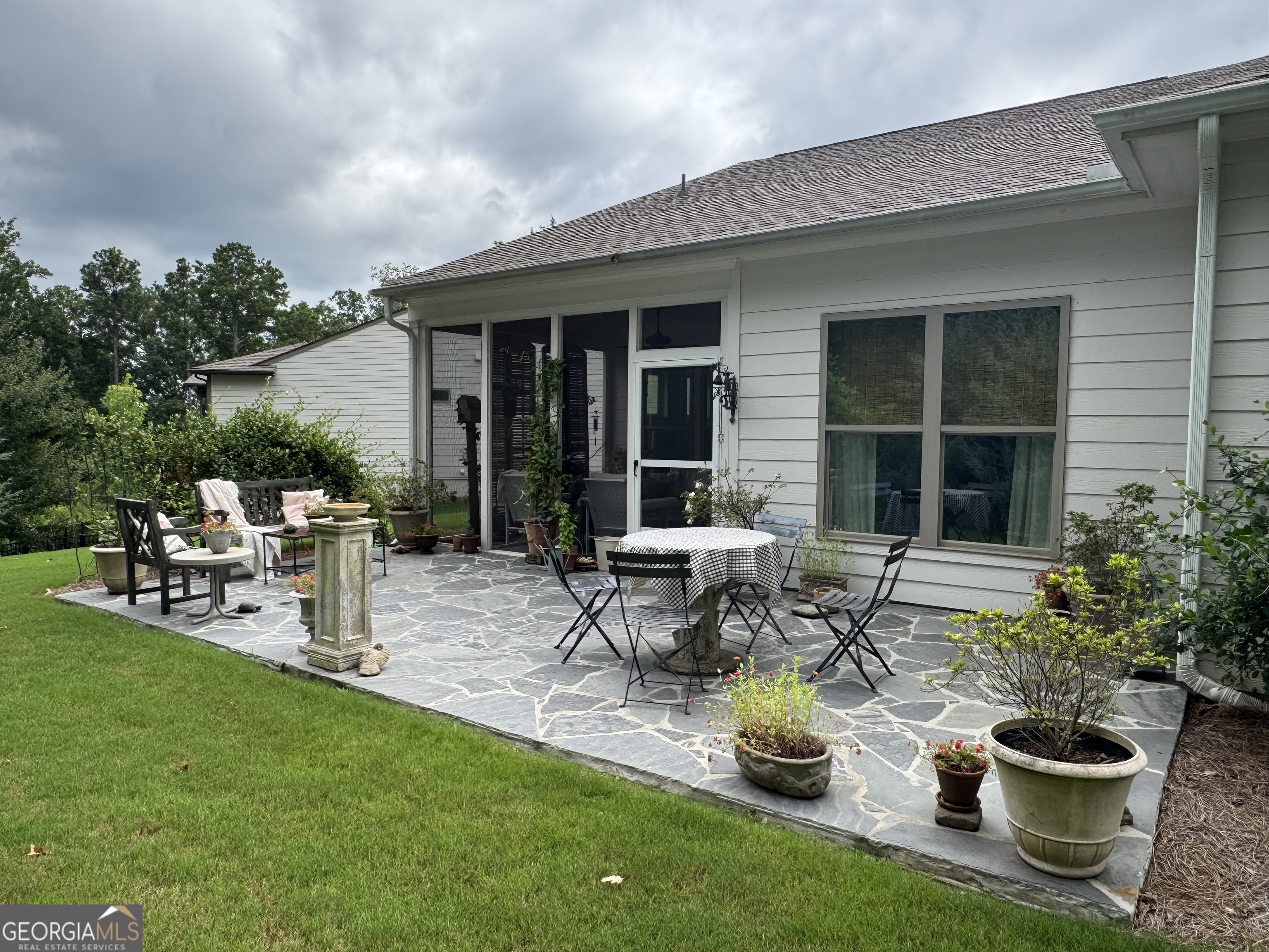 5947 Maple Bluff Way Hoschton, GA 30548 - Photo 3 of 32 a view of a house with backyard sitting area and garden