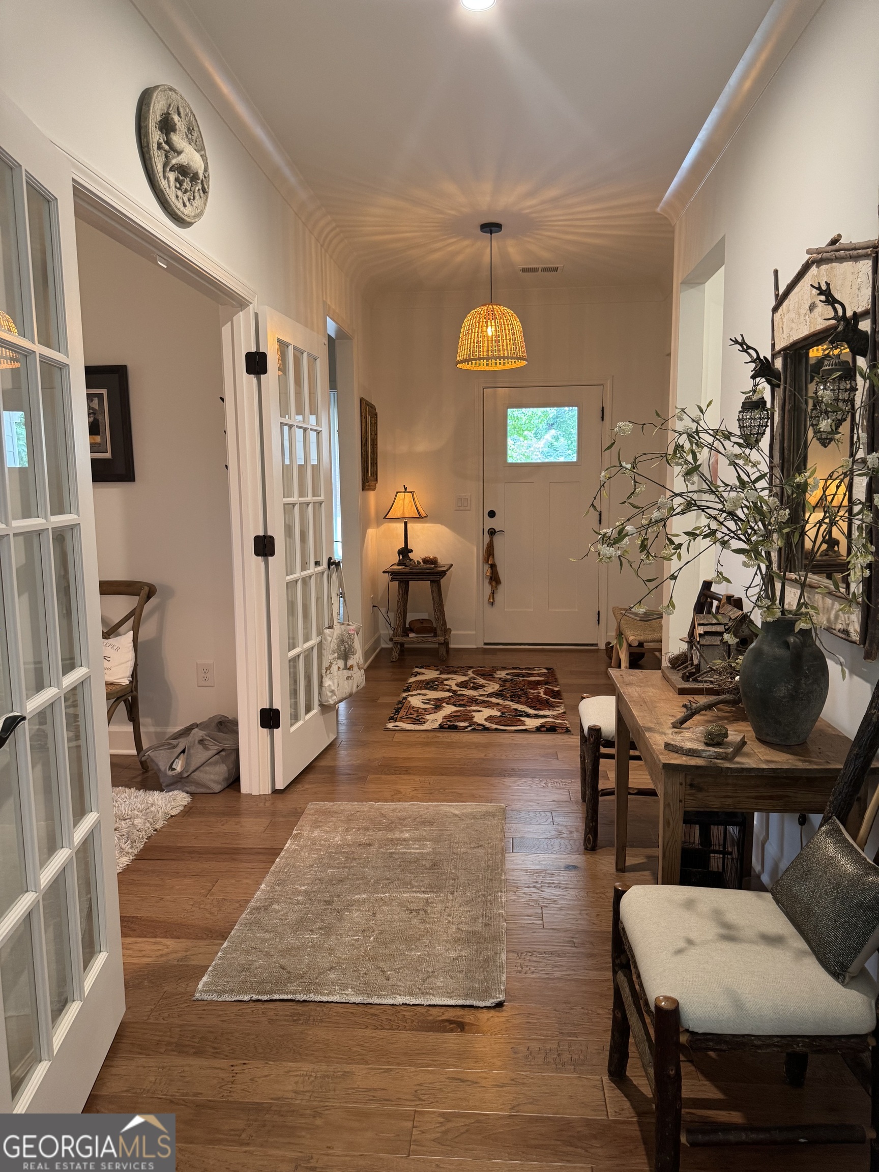 5947 Maple Bluff Way Hoschton, GA 30548 - Photo 5 of 32 a living room with patio furniture and a wooden floor